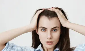 Mujer con las manos en la cabeza, mostrando sus baby hairs y ojos azules intensos.