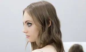 Perfil de mujer con media melena escalada y maquillaje artístico en los ojos.