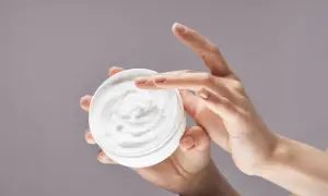 Manos aplicando crema hidratante. La urea en las cremas ayuda a retener la humedad, dejando la piel suave.