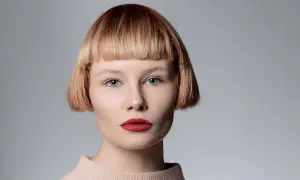 Mujer con pelo corto con flequillo desfilado, ojos azules y labios rojos.