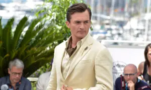 Hombre con un impecable corte de pelo old money, viste un traje de lino color crema y un pañuelo de seda.