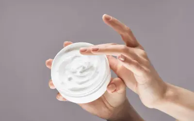 Manos aplicando crema hidratante. La urea en las cremas ayuda a retener la humedad, dejando la piel suave.