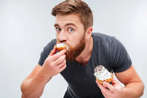 Hombre con barba comiendo pastelitos, ¿es esto un ejemplo de glicación?