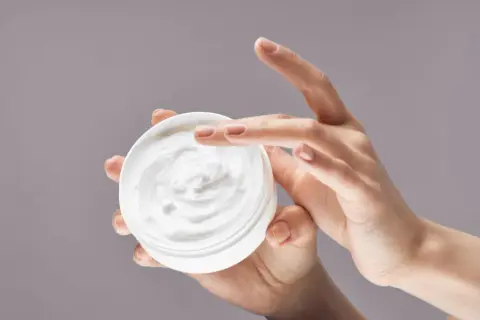 Manos aplicando crema hidratante. La urea en las cremas ayuda a retener la humedad, dejando la piel suave.
