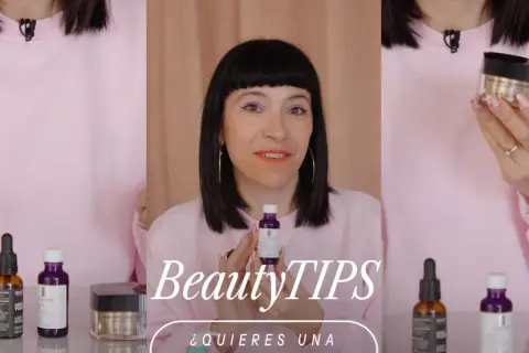 Mujer con maquillaje vibrante y un suéter rosa muestra productos de belleza, buscando un efecto glow cara.