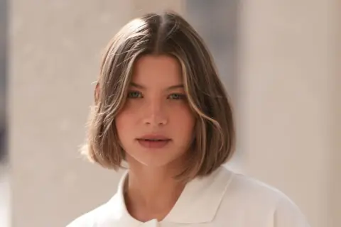 Mujer con un moderno corte bob a capas, con ondas suaves y un toque de rubio en las puntas.