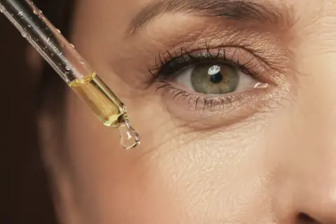 Gota de aceite con vinagre de manzana para la cara, aplicada cerca del ojo.