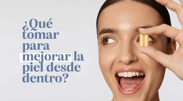 Mujer sonriente sostiene dos cápsulas amarillas, preguntándose qué tomar para mejorar la piel de la cara desde dentro.