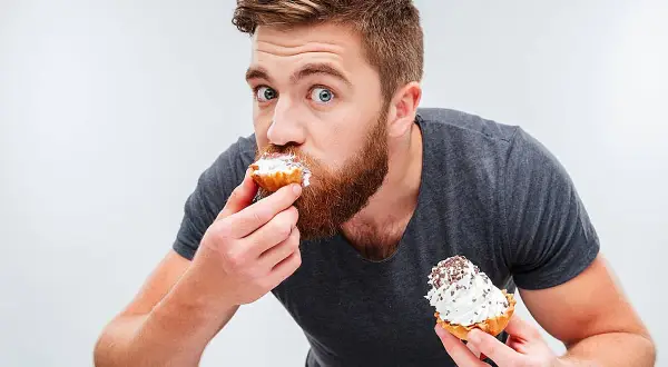 Hombre con barba comiendo pastelitos, ¿es esto un ejemplo de glicación?