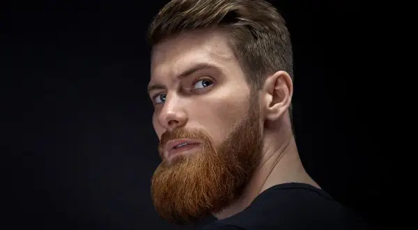 Hombre con barba y cortes de pelo hombre elegante, mirada intensa.