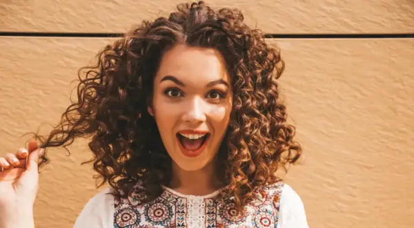 Mujer con cabello rizado y voluminoso, que parece que no le gusta que le apelmacen el cabello.