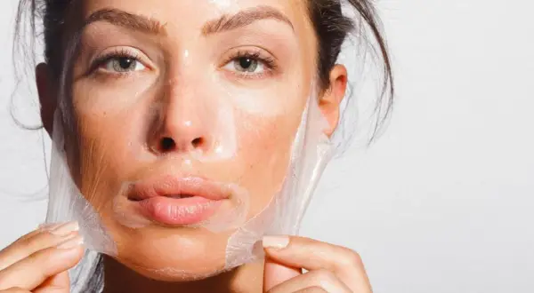 Mujer retirando una mascarilla de su rostro, un paso clave para como alisar la piel de la cara y lograr un cutis radiante.
