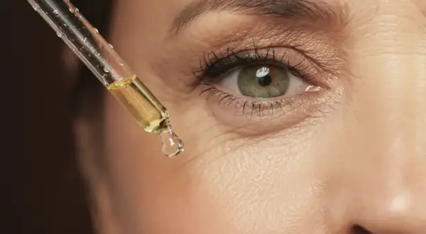 Gota de aceite con vinagre de manzana para la cara, aplicada cerca del ojo.