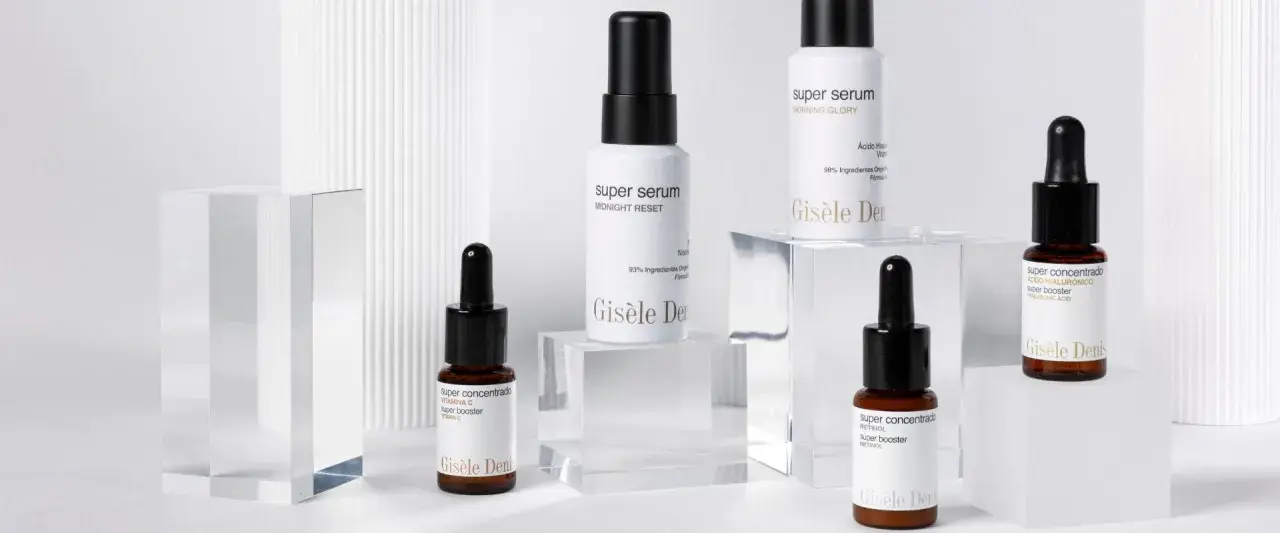 Varios frascos de sérum y super booster de Gisèle Denis, con etiquetas que detallan sus ingredientes y beneficios.