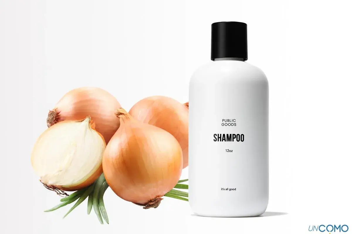 Champú de cebolla con propiedades beneficiosas para el cabello. Cebollas frescas y un frasco de champú blanco sobre fondo blanco.