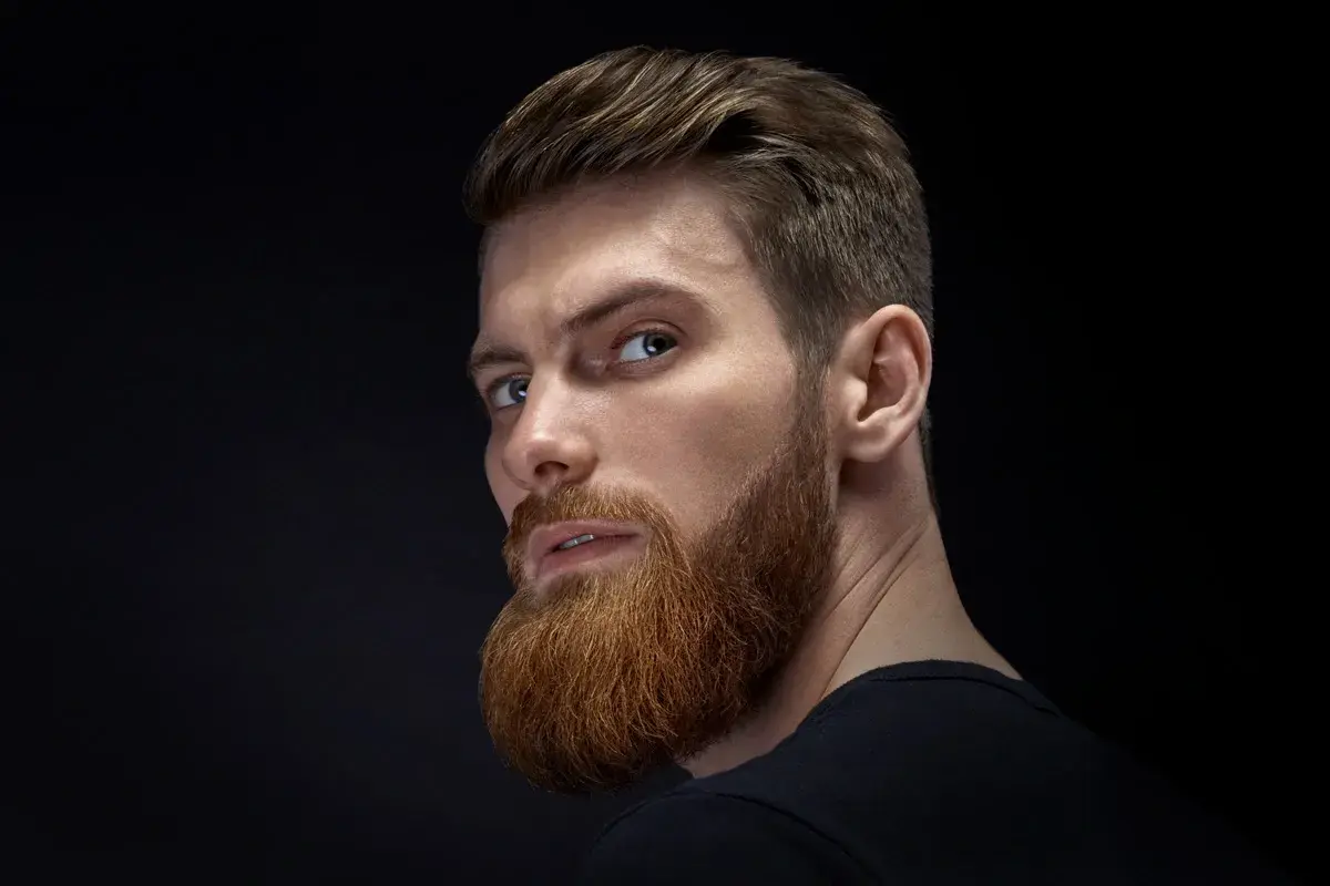 Hombre con barba y cortes de pelo hombre elegante, mirada intensa.