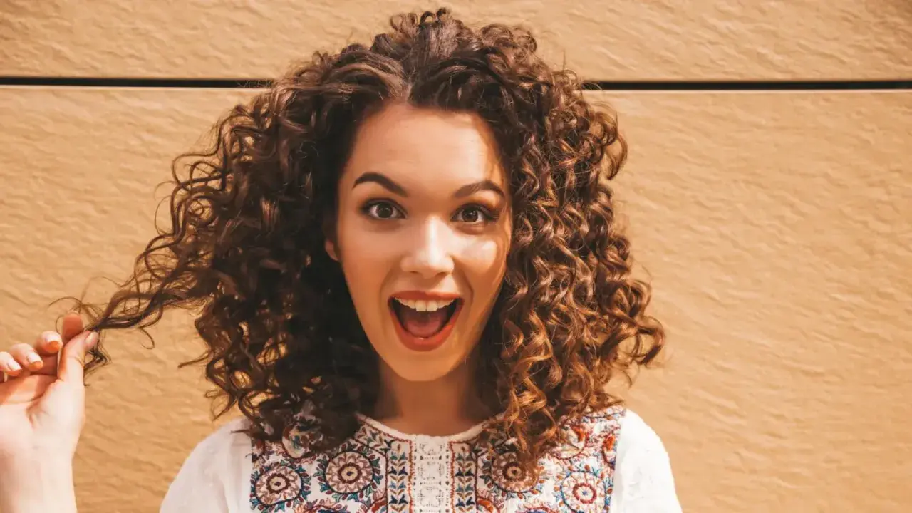 Mujer con cabello rizado y voluminoso, que parece que no le gusta que le apelmacen el cabello.