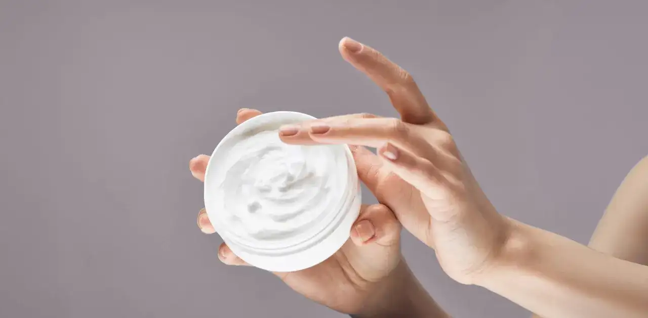 Manos aplicando crema hidratante. La urea en las cremas ayuda a retener la humedad, dejando la piel suave.