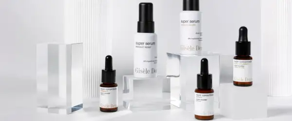 Varios frascos de sérum y super booster de Gisèle Denis, con etiquetas que detallan sus ingredientes y beneficios.
